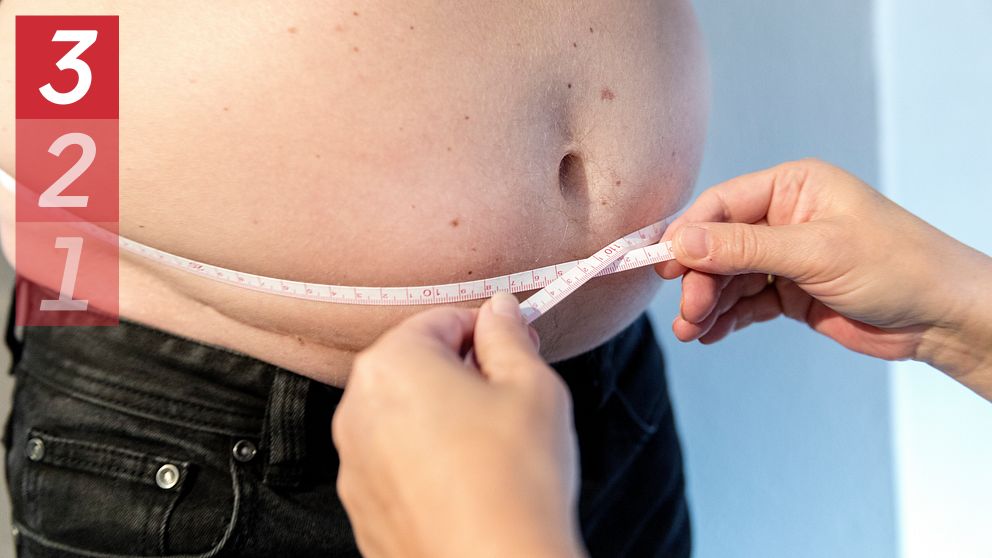 Måttband runt mage på man