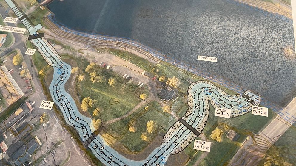 Karta över ett område med en vattenväg som lutar sig genom en park. Blå linjer markerar vattenflödet, och olika punkter med mått finns utmärkta längs vägen. Området innehåller grönskande vegetation och är omgivet av byggnader och infrastruktur.