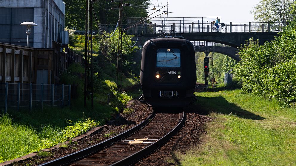 Ett öresundståg på ett spår under en bro.