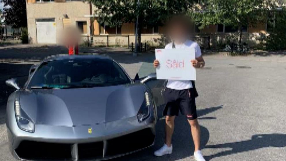 Man framför ferrari som håller i skylt som det står SÅLD på