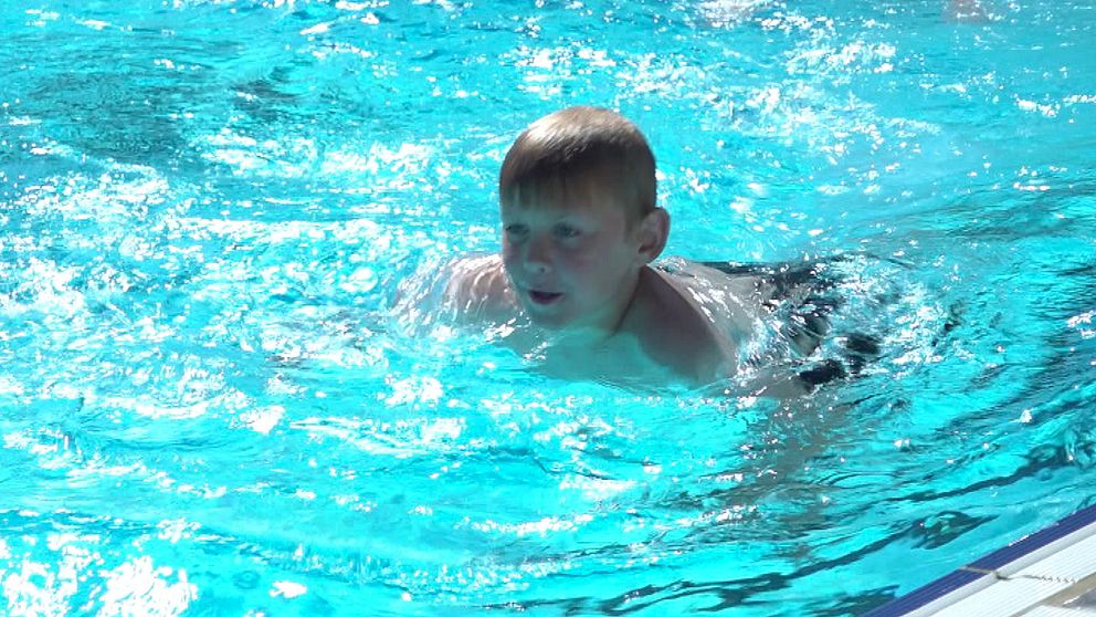 Pojke simmar i pool.