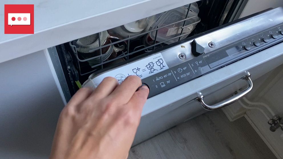 En hand trycker på en diskmaskin