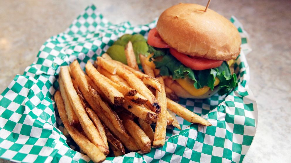 Hamburgare med pommes frites i en korg.