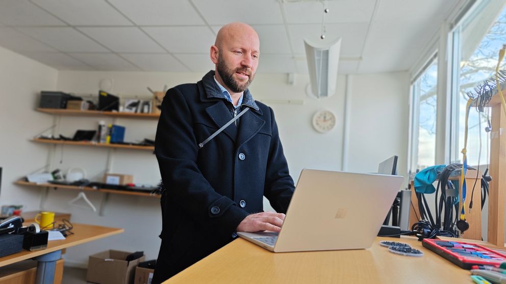Man står vid laptop