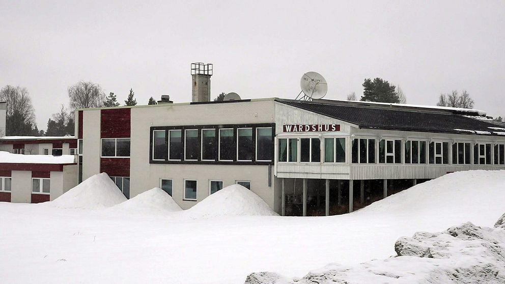 En stor vit byggnad omgiven av ett snötäckte.