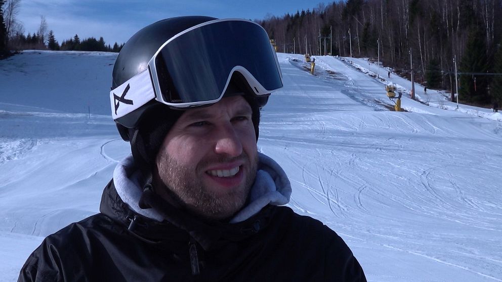 Joakim Bergdahl med skidhjälm i pisten, omgiven av snö och skog i bakgrunden.