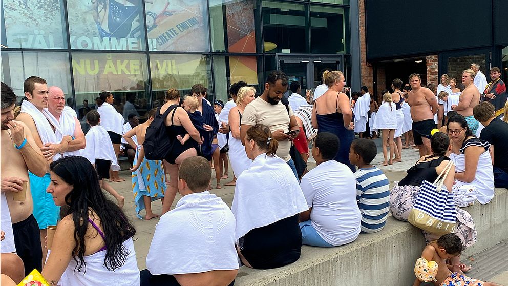 En stor samling badklädda personer står utanför äventyrsbadet Kokpunkten i Västerås.