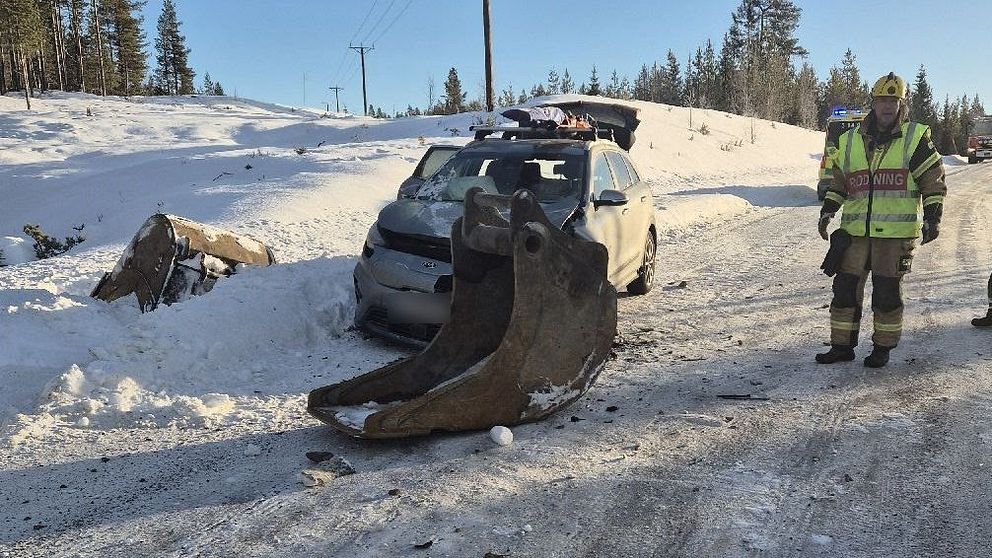 Bilolycka på snötäckt väg, bärgare och bil med skador ses i bakgrunden.