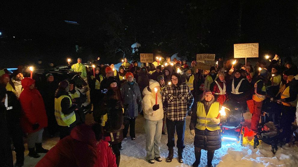 Flera personer i ett fackeltåg.