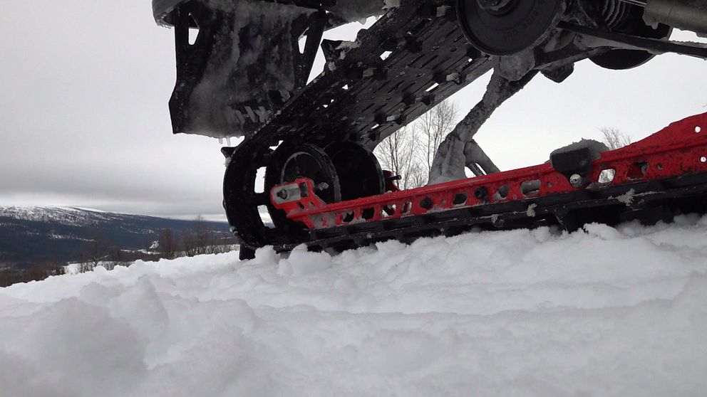 Närbild av snöskotertillbehör i snön på snötäckt landskap.