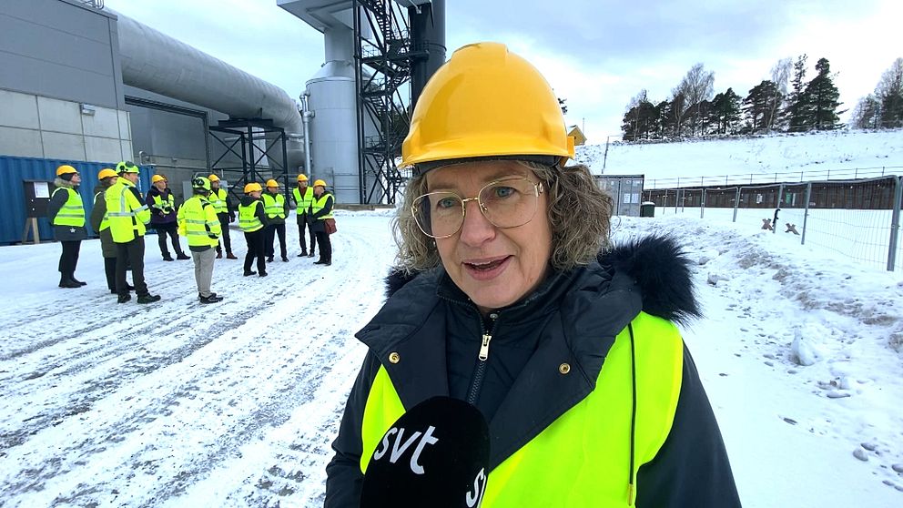 kvinna i varselväst och gul hjälm