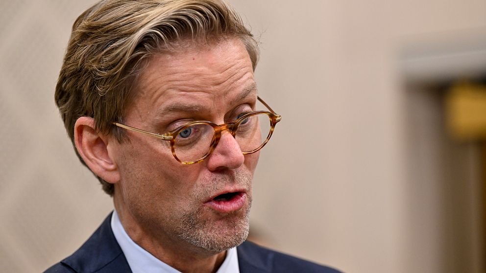 Jakob Olofsgård i kostym intervjuas med mikrofon.