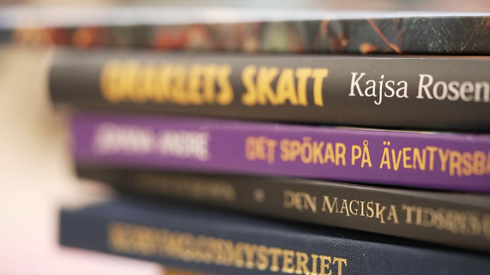 Närbild på en stapel böcker för barn och unga med titlarna synliga på bokryggarna.