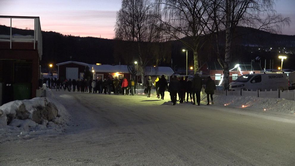 Elever går på led. Marschaller lyser upp vägen i Sveg.