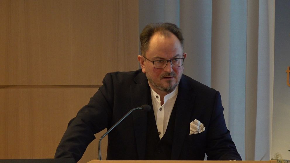 Person med kostym i en talarstol.