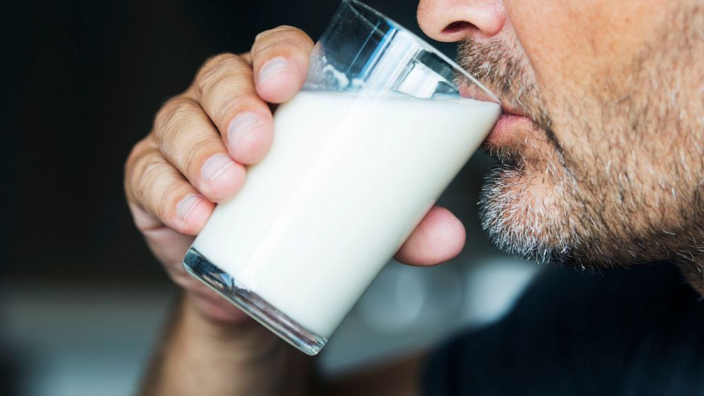 En man dricker ett glas mjölk.