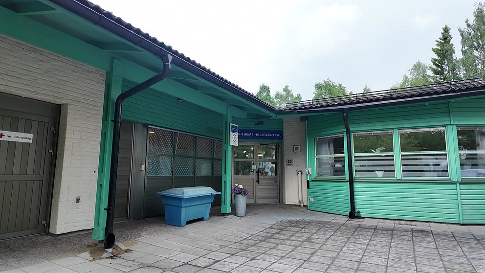 Exteriörbild på Mariehems hälsocentral i Umeå. Vitt tegel och grön träfasad.