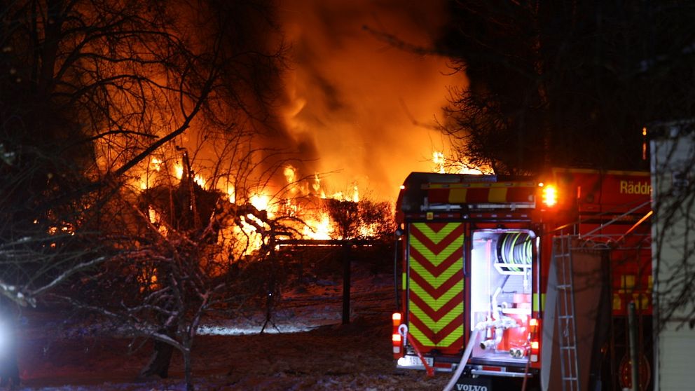 Villa i lågor. Brandbil står bredvid