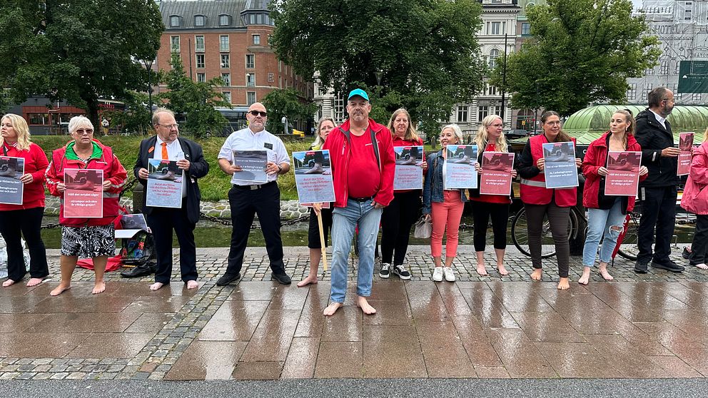 Representanter från fackförbundet Kommunal och busschaufförer manifesterar barfota.