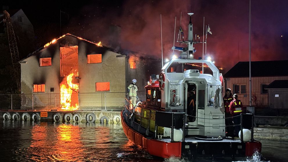 Sjöräddningssällskapet i Strömstad framför en brinnande lokal.