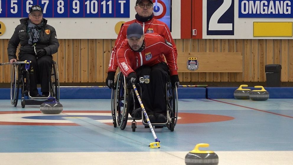En man i rullstol spelar curling