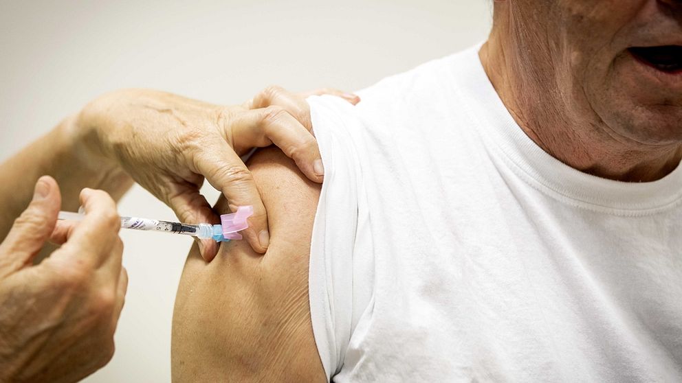 Äldre man får vaccination mot covid 19.