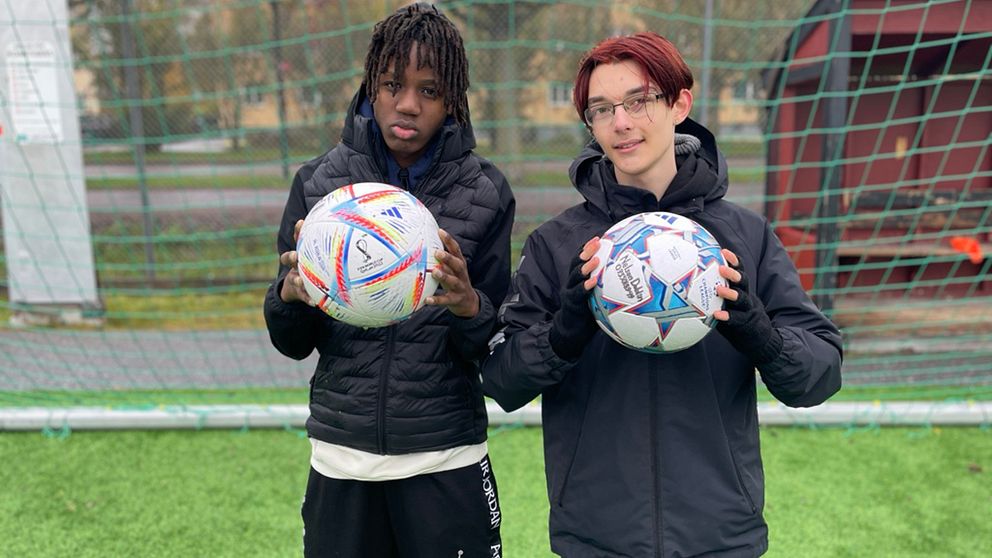 två unga killar som håller i varsin fotboll