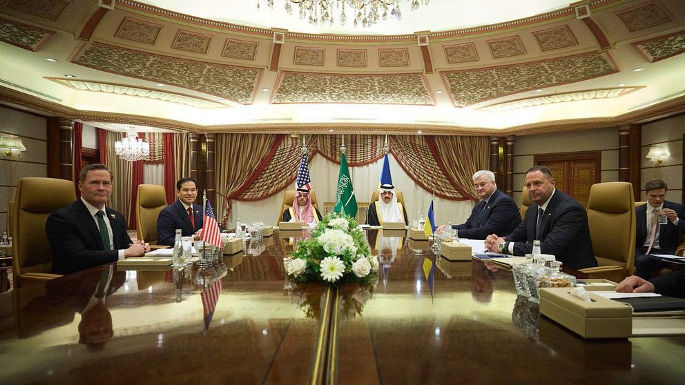 Möte i elegant konferensrum med representanter från USA och Saudiarabien.