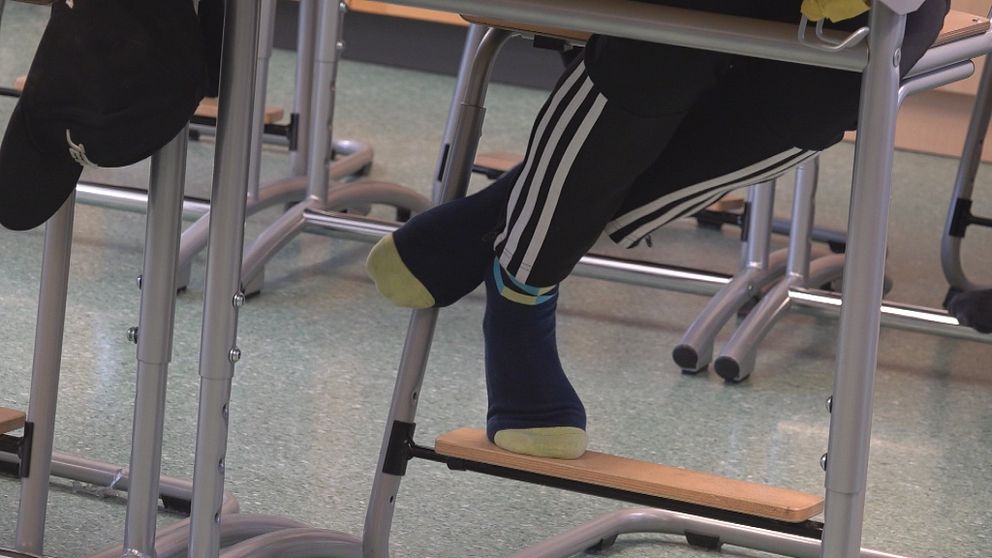 En bild på ben under en skolbänk.