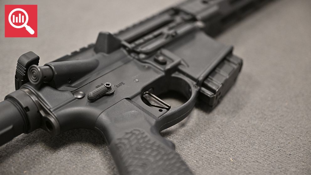 Ett närbildsfoto av en AR-15-stormgevär, fokuserat på avtryckaren och delar av pistolgreppet, med en suddig bakgrund.