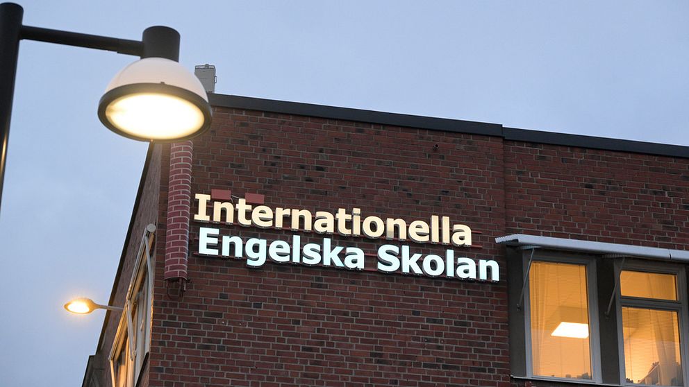 En bild på ett hus med skylten internationella engelska skolan i kvällsljus