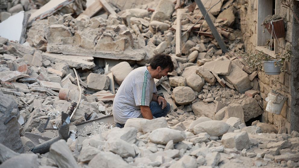 En man gråter efter att ha fått sitt hem förstört.