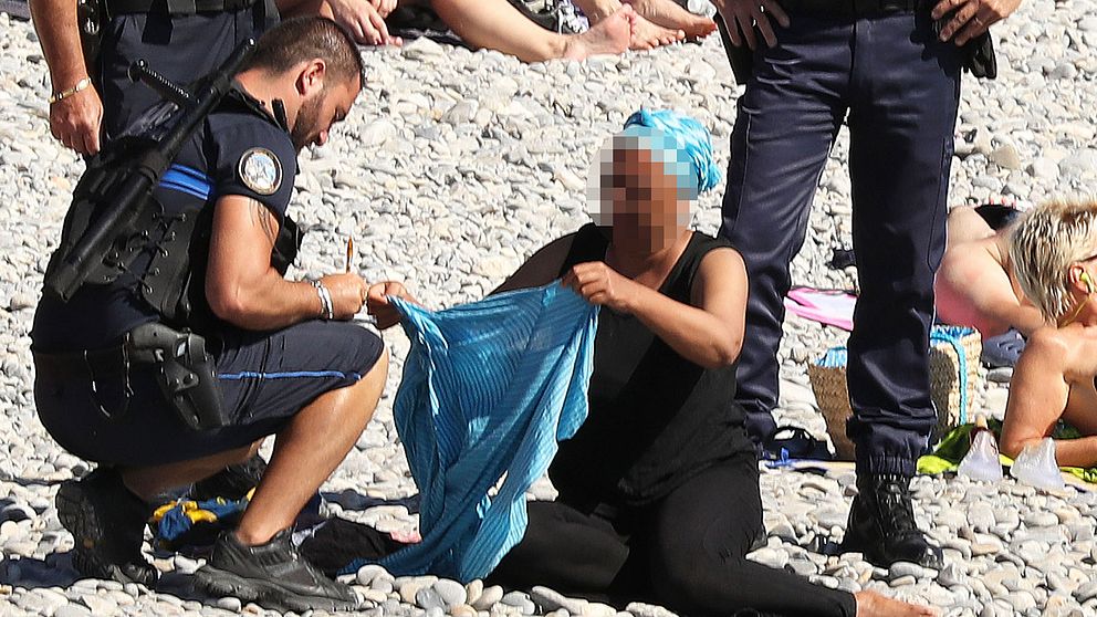 En kvinna tvingades i går av fransk polis att ta av sig sin heltäckande tunika på en strand i Nice. 15 städer i Frankrike har infört ett förbud mot burkinin – däribland Nice.