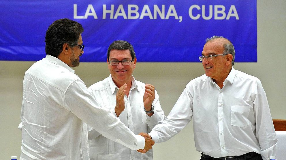 Farc-befälhavaren Ivan Marquez och den colombianska regeringens förhandlare Humberto de la Calle skakar hand efter signeringen av fredsavtalet.