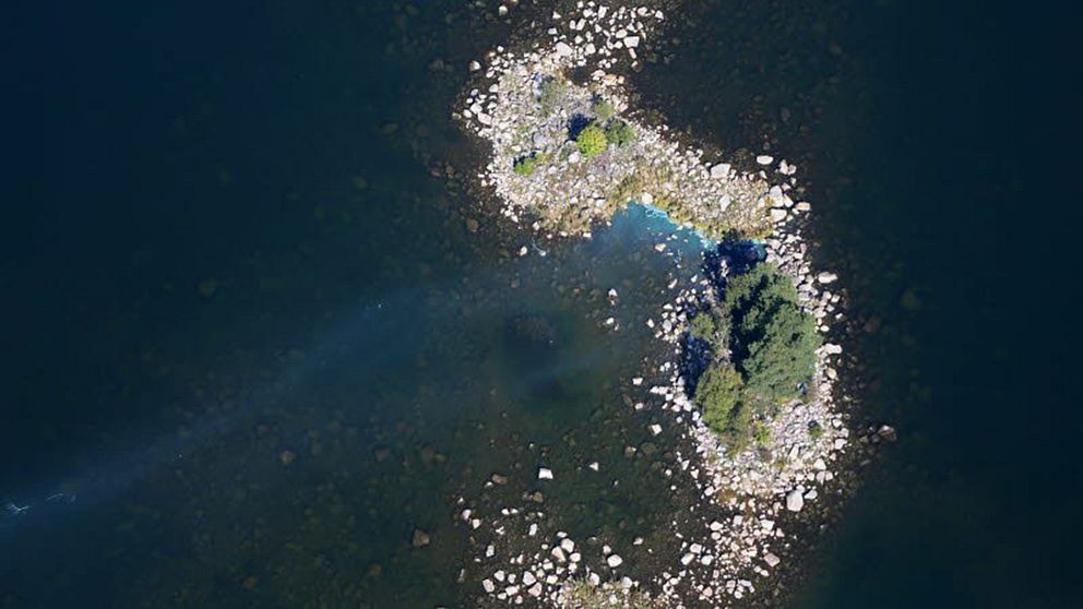 flygfoto av liten stenig ö med några träd