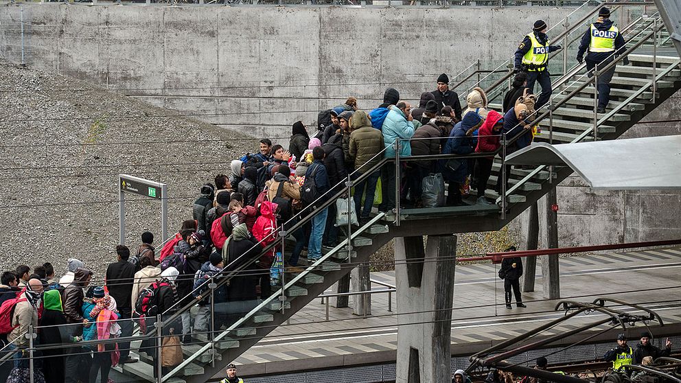 Polis övervakar kön av ankommande flyktingar i snålblåsten vid Hyllie station utanför Malmö i november 2015.