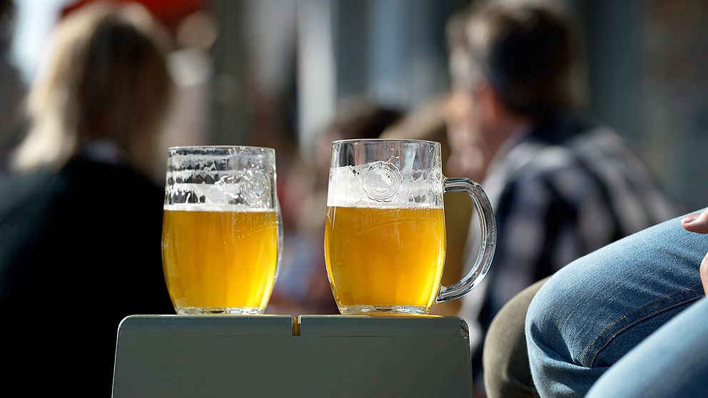 Två ölglas i solen på en uteservering.