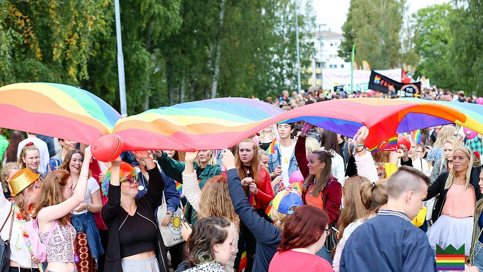 Unga människor med en regnbågsflagga.