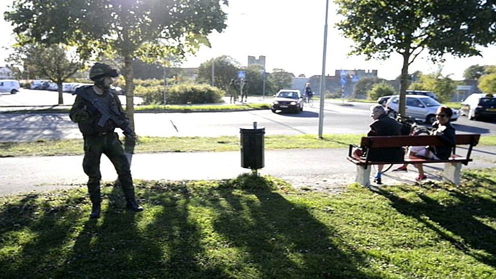 Soldat står och tittar på en parkbänk