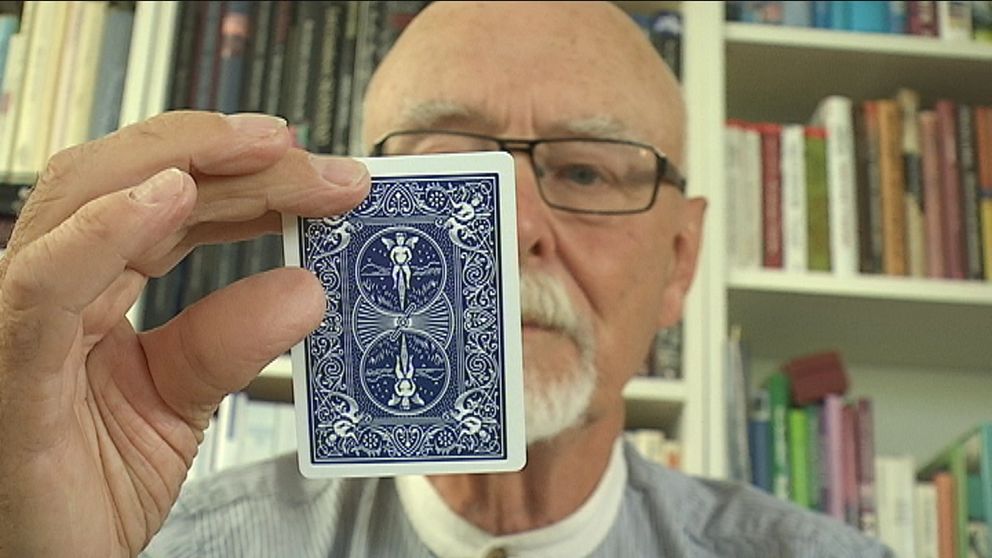 Erik Luttropp håller upp ett spelkort.