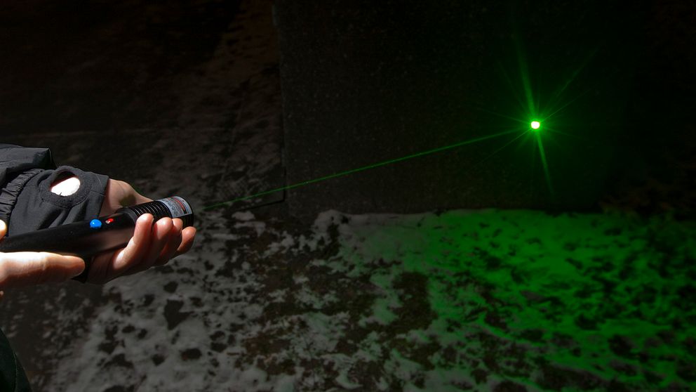 Laserpekare med grön laser i mörker.