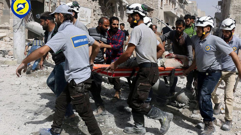Räddningsarbetare i ett rebellkontrollerat område i östra Aleppo, som attackerades av stridsflyg på onsdagen. Bilden har tagits av frivilligkåren Vita hjälmarna.
