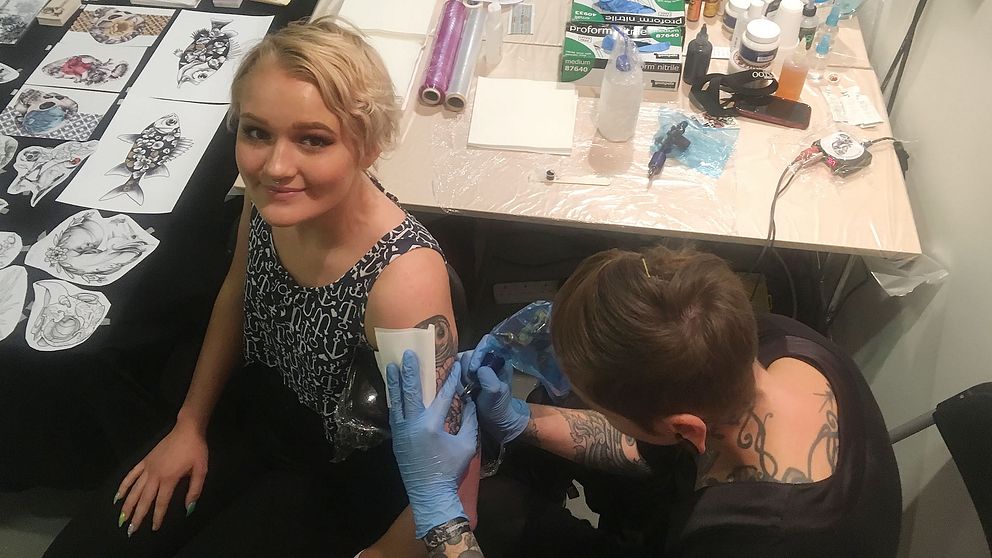 Tatueringsmässa, tjej blir tatuerad.