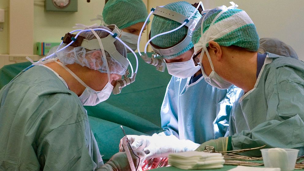 Läkare och operationssjuksköterskor som opererar. Genrebild
