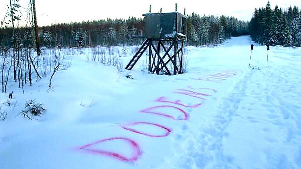 Jakttorn i snö med texten ”Dödens ring” skrivet med röd text i snön nedanför