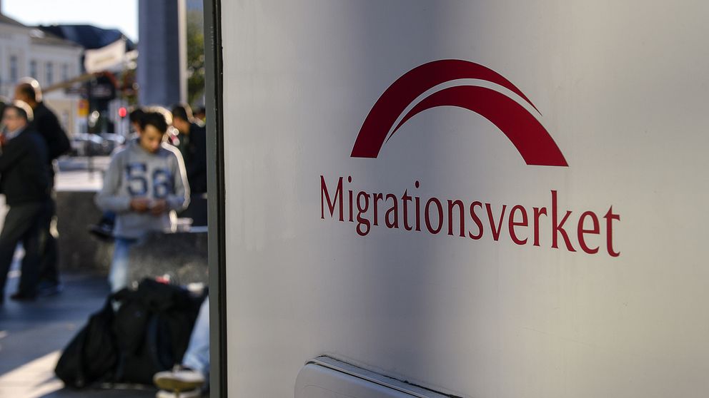 Migranter och Migrationsverket-skylt.