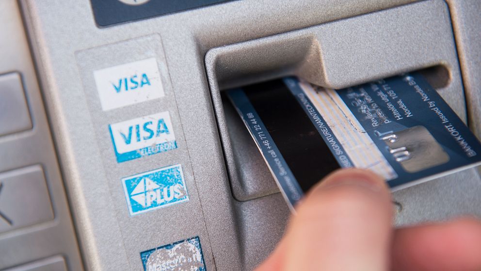 En bild på någon som sätter in ett bankkort i en bankomat.