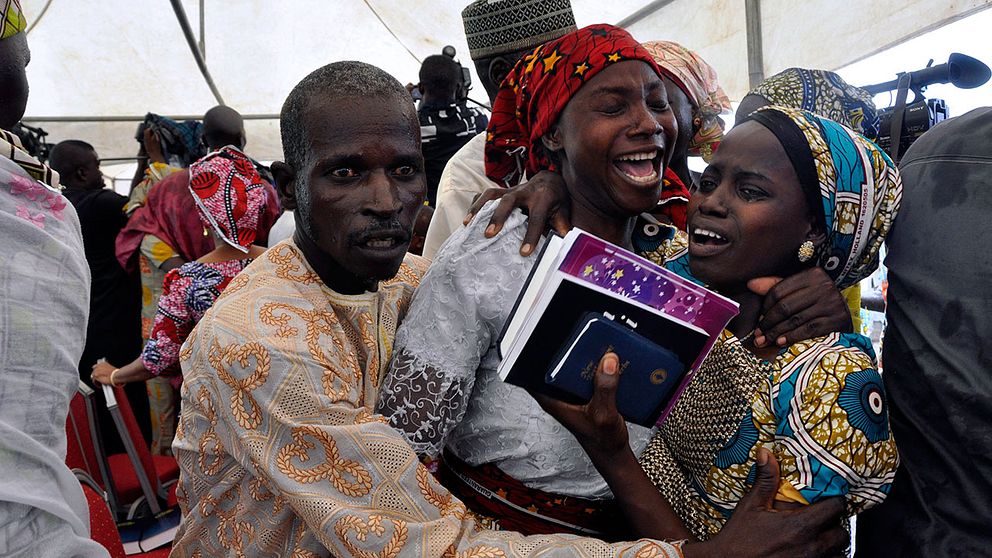 En av de kidnappade flickorna firar med sin familj under en gudstjänst i Nigerias huvudstad Abuja på söndagen.