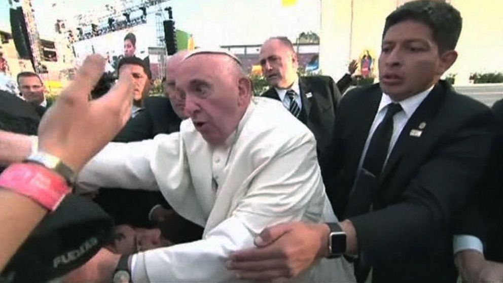Påven dras ner över åskådare och ryter ifrån.