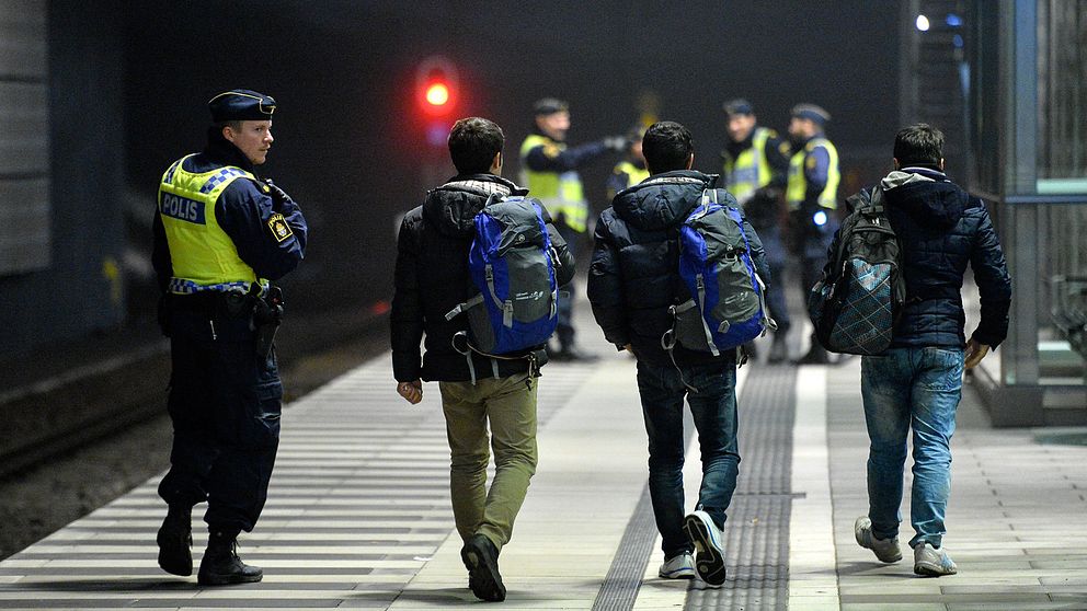 Polis eskorterar asylsökande från ett Öresundståg som stannat vid Hyllie station utanför Malmö efter genomförd gränskontroll.